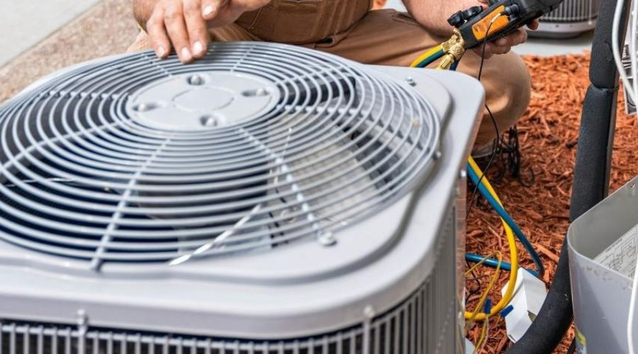 Technician repairing an air conditioning unit, emphasizing HVAC maintenance at The Bosworth Company Kerrville.