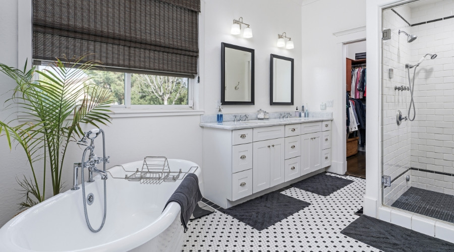 Modern bathroom featuring a freestanding tub, dual vanities with mirrors, stylish fixtures, and a glass shower, emphasizing comfort and aesthetic appeal in bathroom renovations.